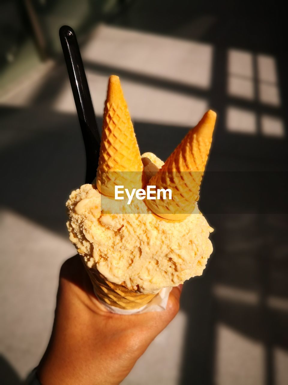 CROPPED IMAGE OF HAND HOLDING ICE CREAM CONE