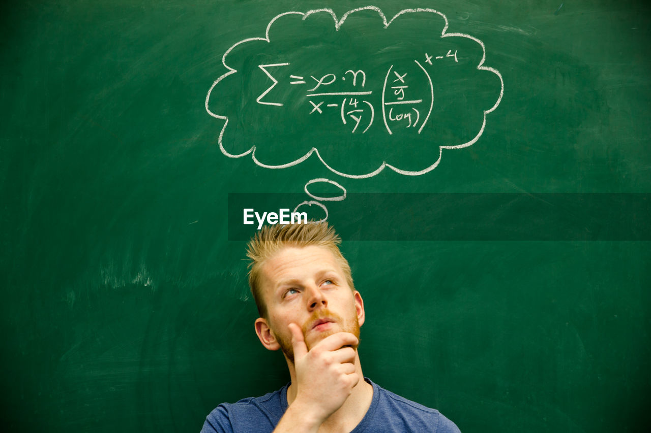 Man with mathematical formula on blackboard