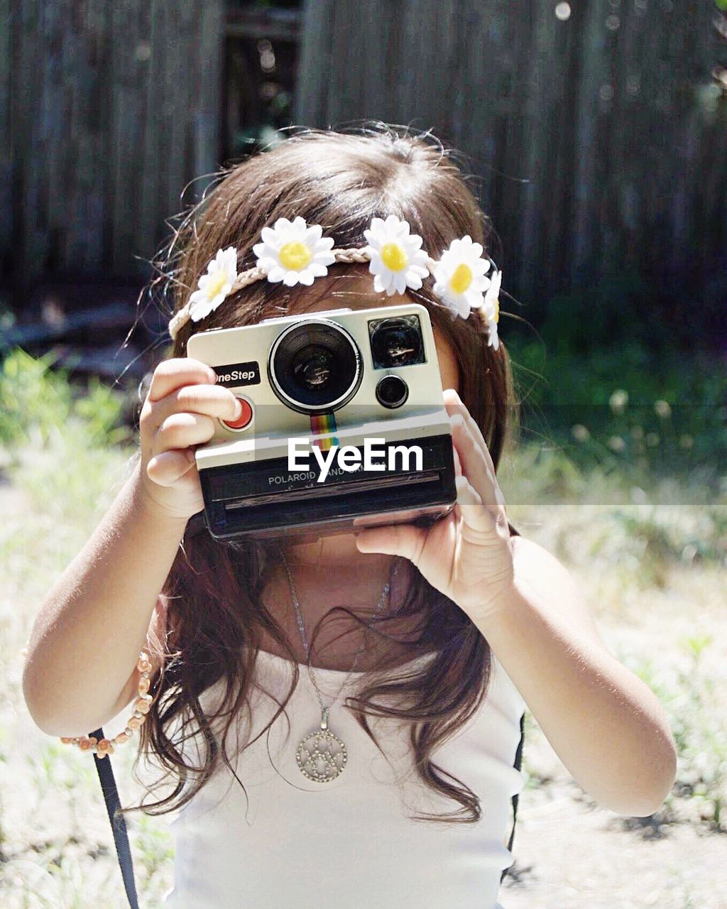 CLOSE-UP PORTRAIT OF YOUNG WOMAN WITH CAMERA