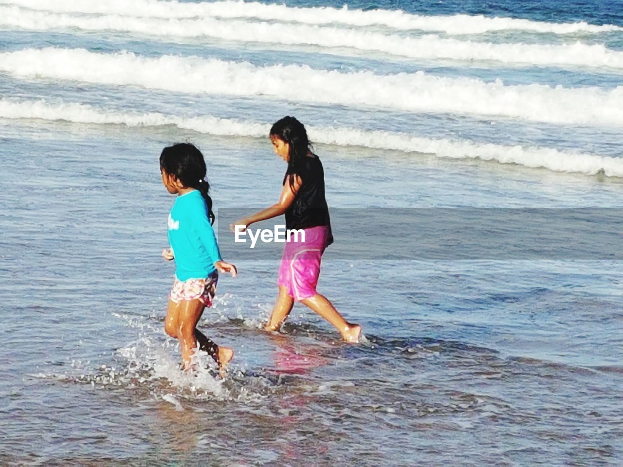 FULL LENGTH OF FRIENDS ENJOYING ON BEACH