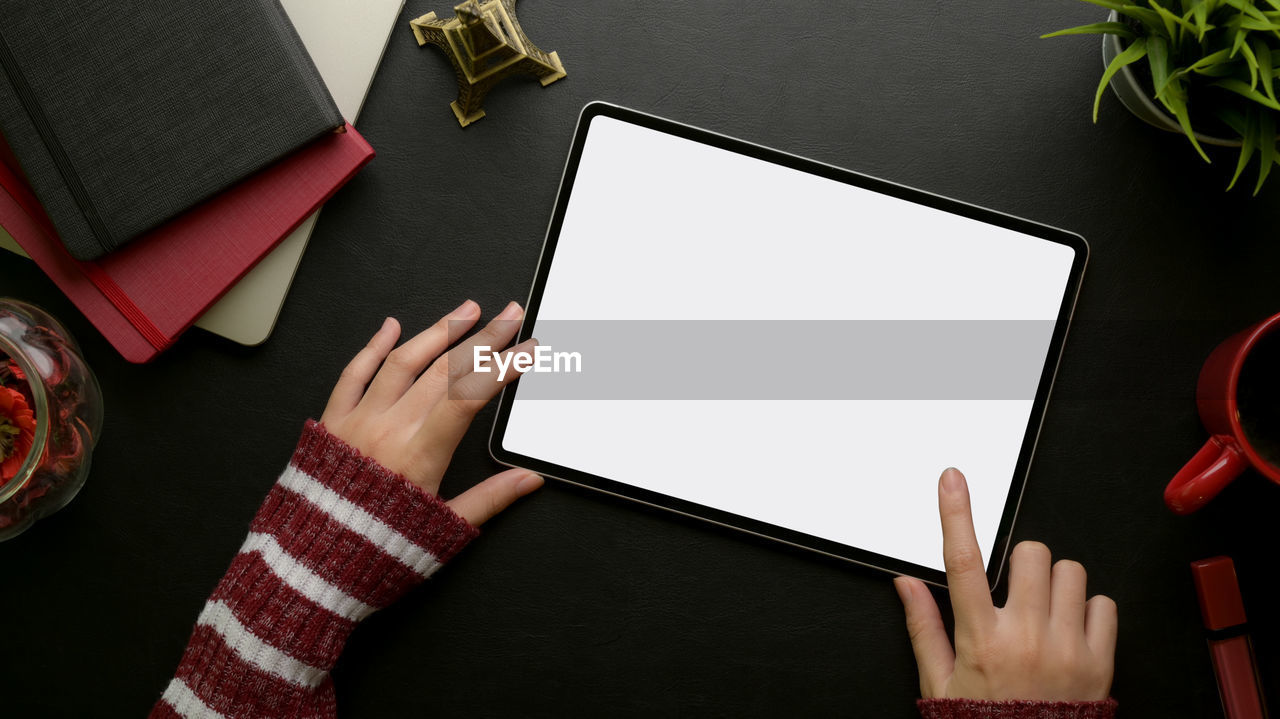 Cropped hands using digital tablet at desk