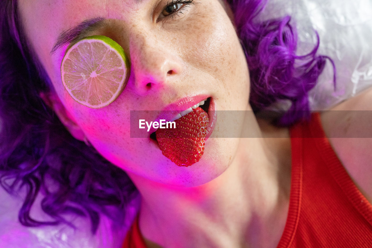 Portrait of woman eating strawberry