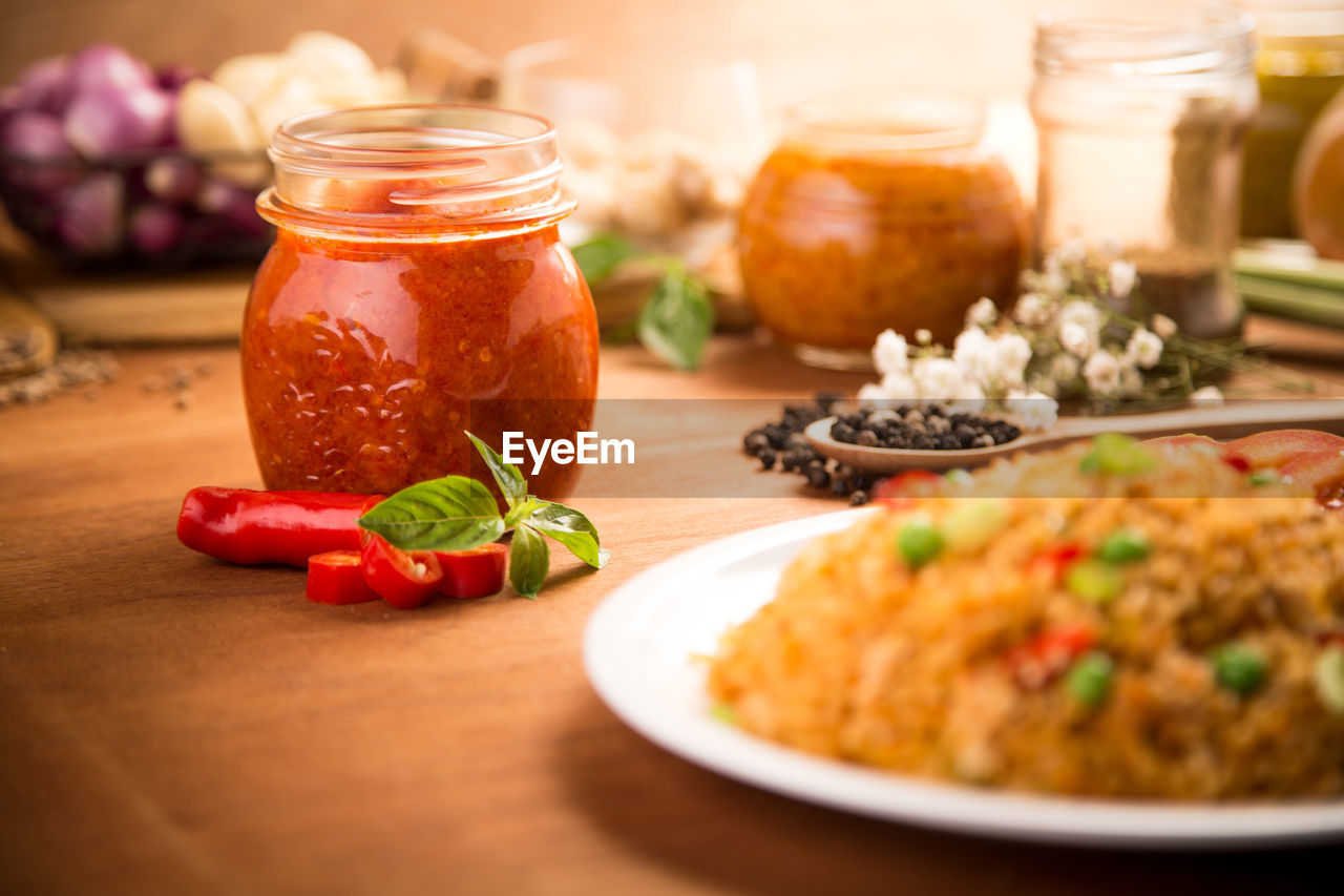 Close-up of food by red chili pepper paste on wooden table