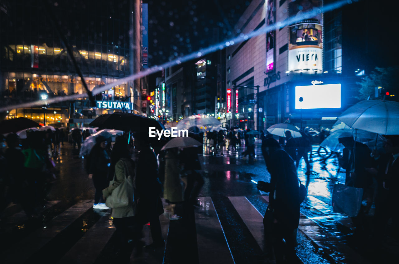 People on street at rainy night in tokyo japan view from my umbrella