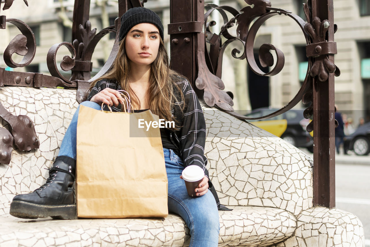 PORTRAIT OF BEAUTIFUL YOUNG WOMAN STANDING AT STORE IN A SHOP