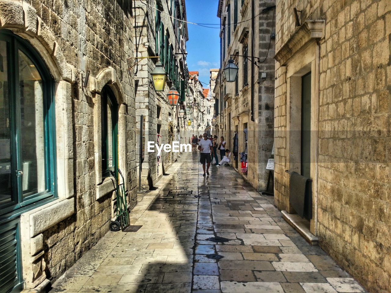 Man walking on footpath amidst buildings