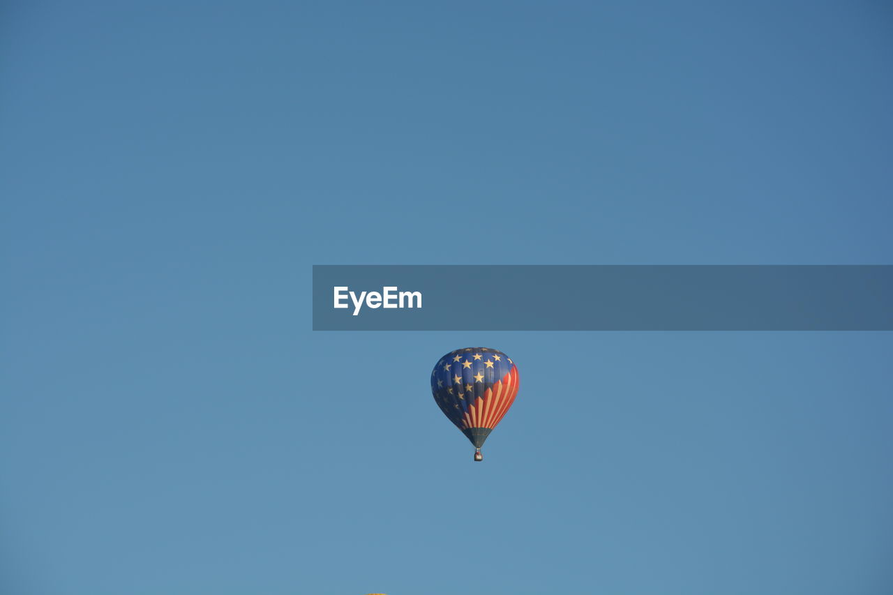 LOW ANGLE VIEW OF HOT AIR BALLOON AGAINST CLEAR SKY