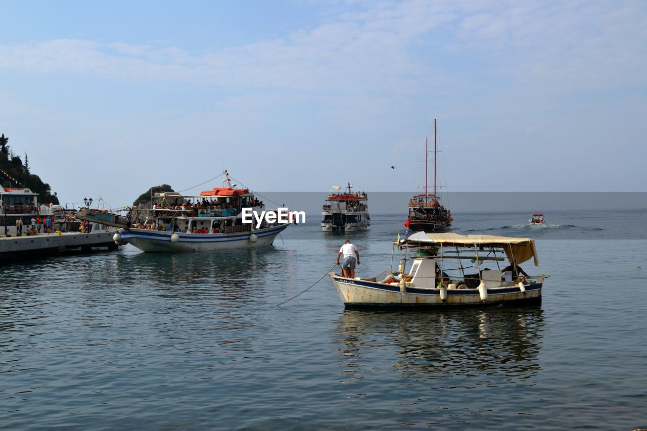 People traveling in boat on sea against sky