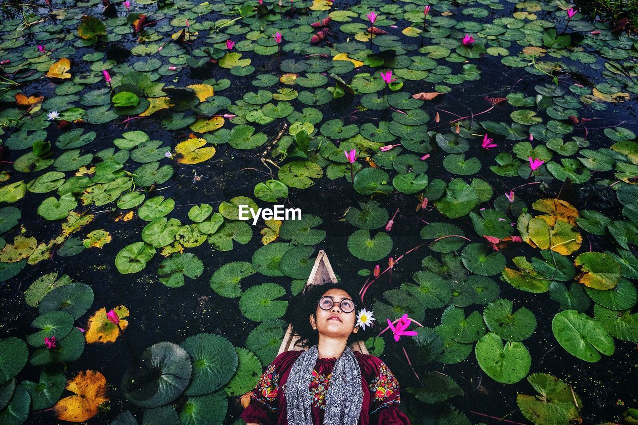 High angle view of woman lying on boat in lake