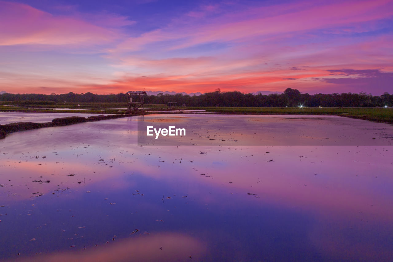 SCENIC VIEW OF LAKE AGAINST ORANGE SKY