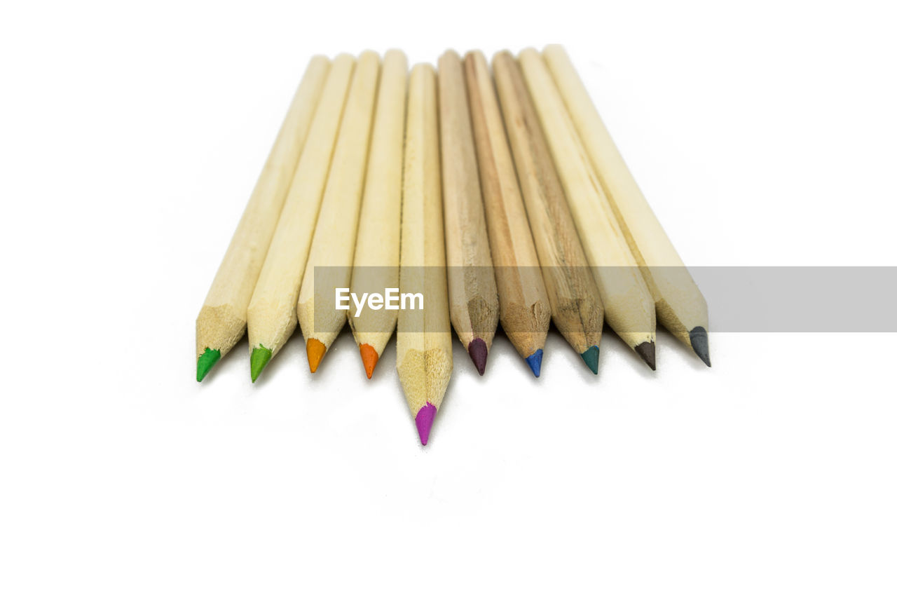 Close-up of colored pencils against white background