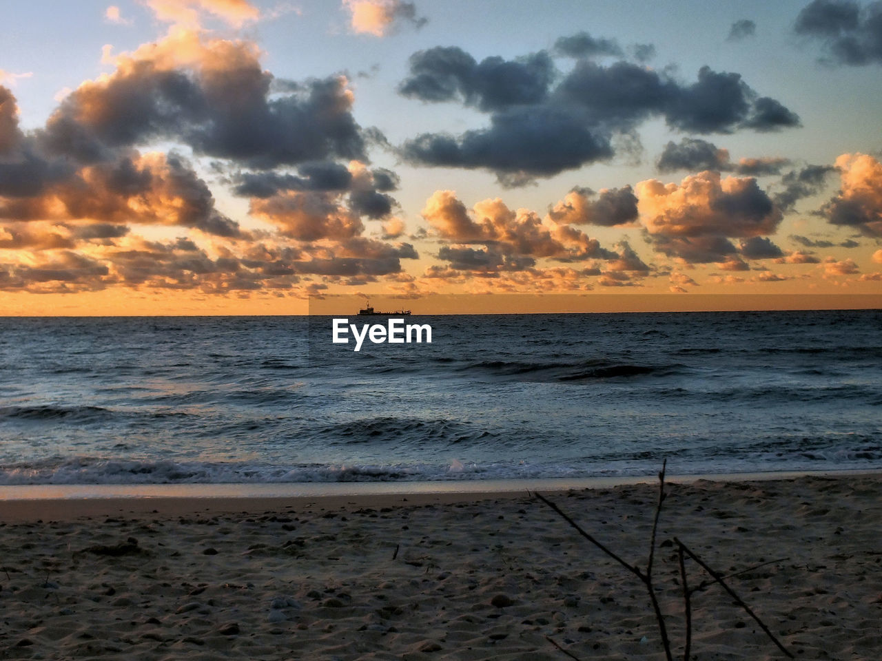 SCENIC VIEW OF BEACH AGAINST SKY AT SUNSET