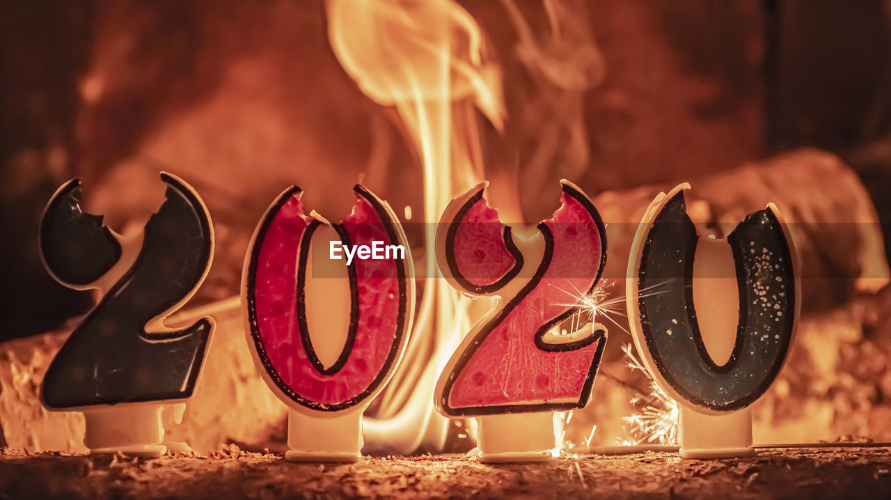 Close-up of 2020 numbers burning on table