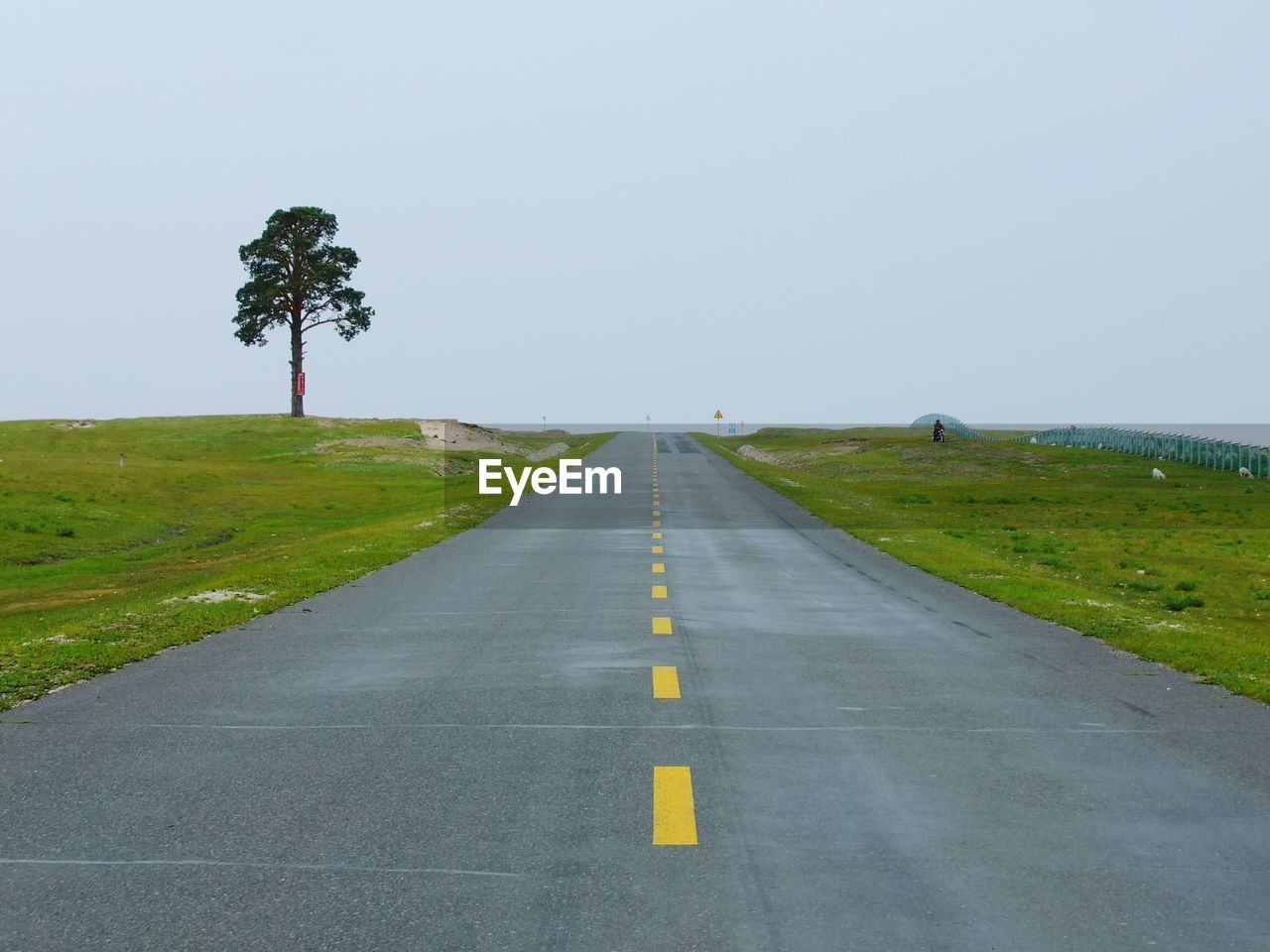 Road amidst green landscape against clear sky