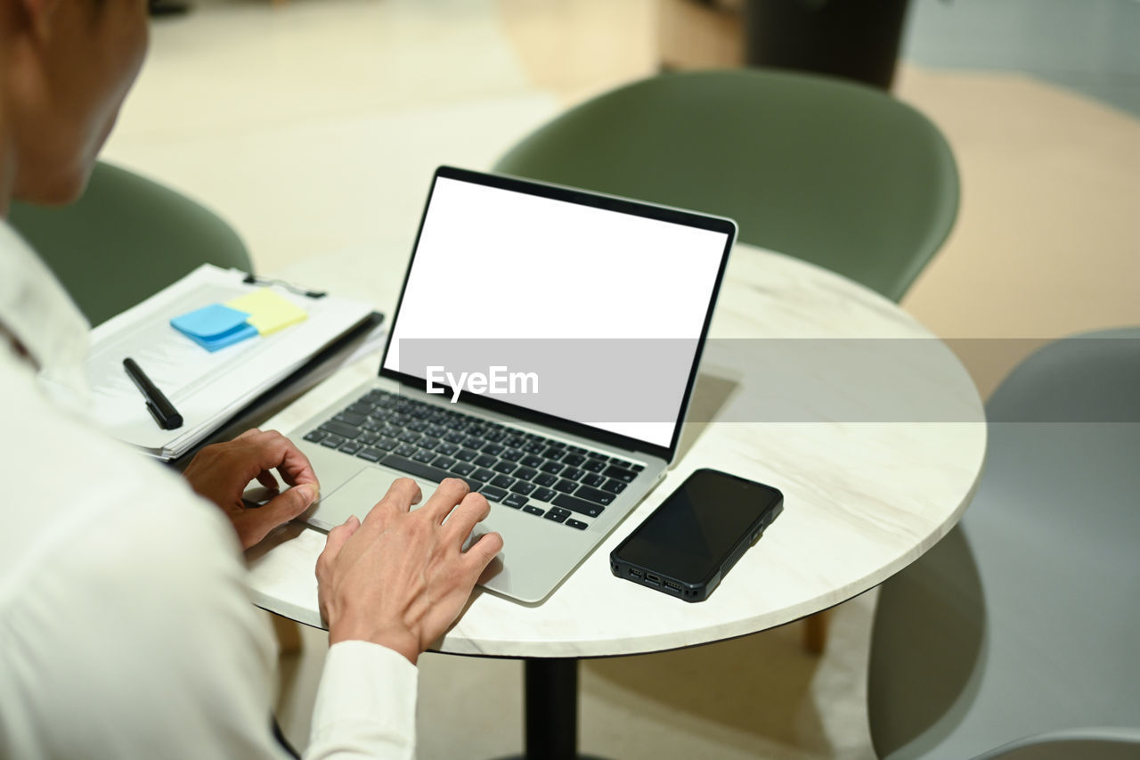 midsection of woman using laptop on table