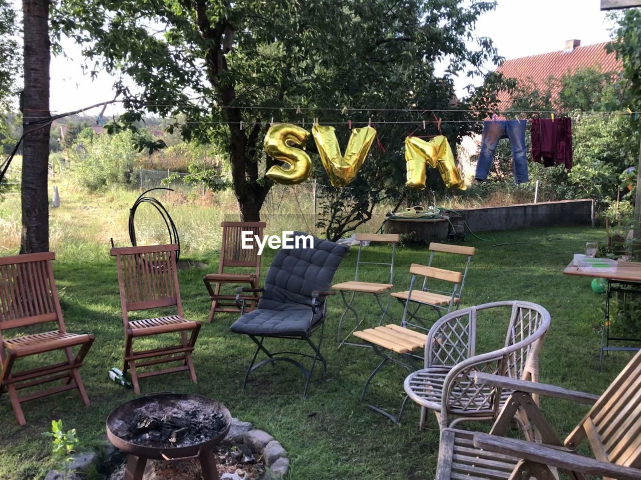 EMPTY CHAIRS AND TABLE IN LAWN