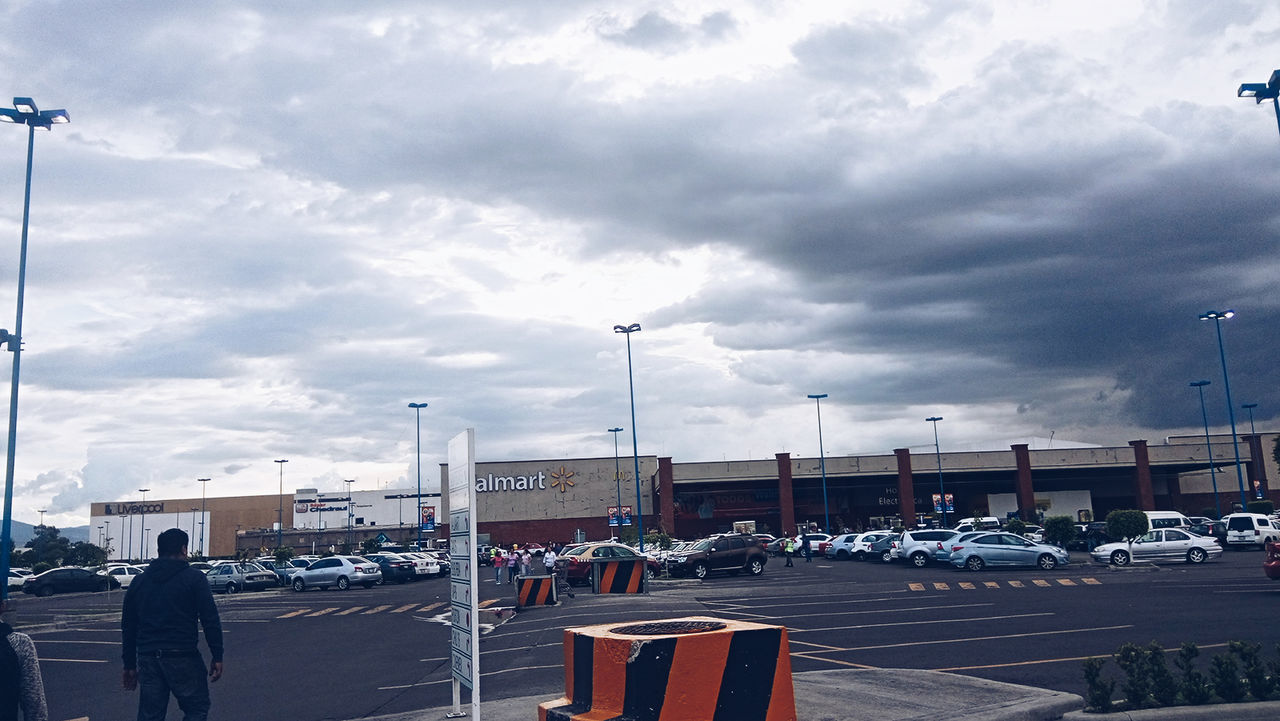 VIEW OF CITY STREET AGAINST CLOUDY SKY