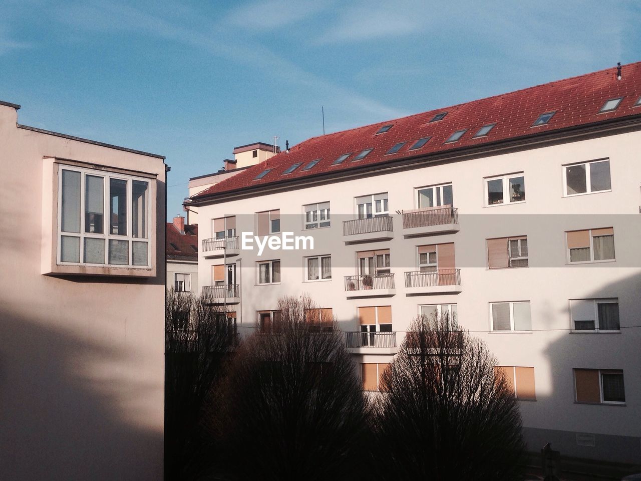 HOUSES BY RESIDENTIAL BUILDING AGAINST SKY