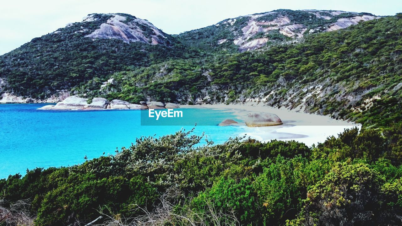 Scenic view of sea and mountains against sky