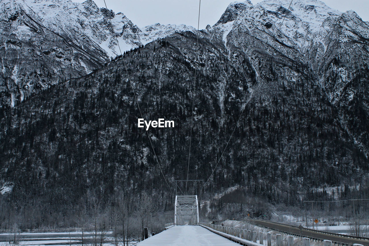 Falling snow on bridge with mountain winter background