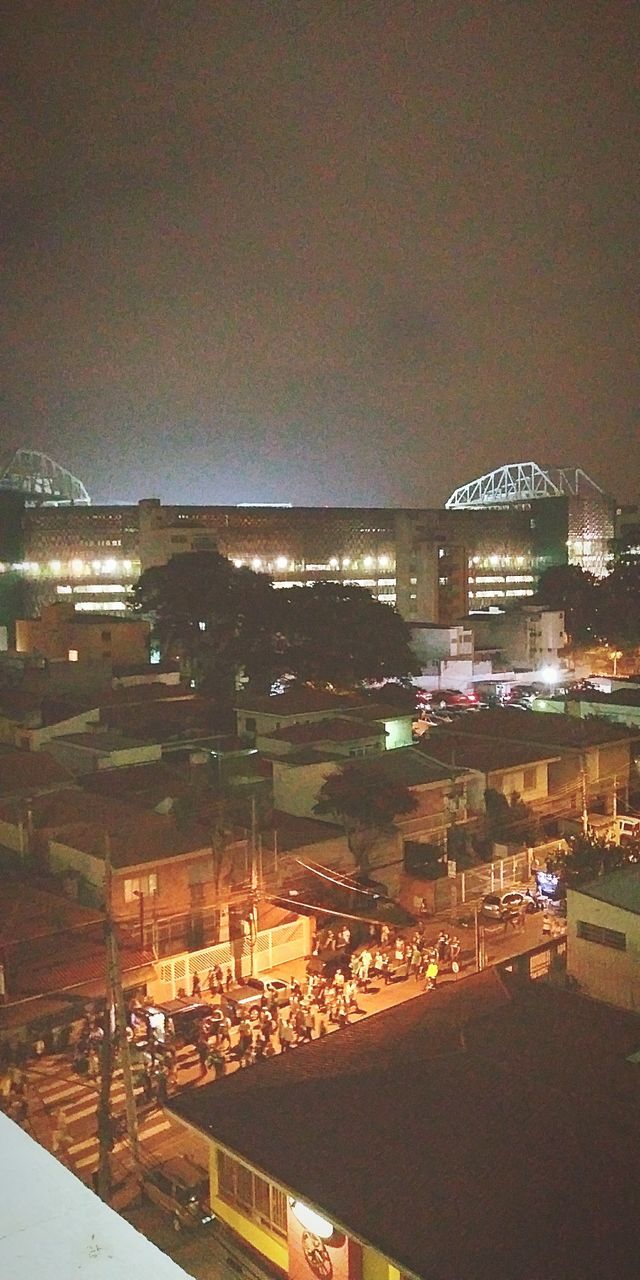 HIGH ANGLE VIEW OF ILLUMINATED CITY BY SEA AGAINST SKY