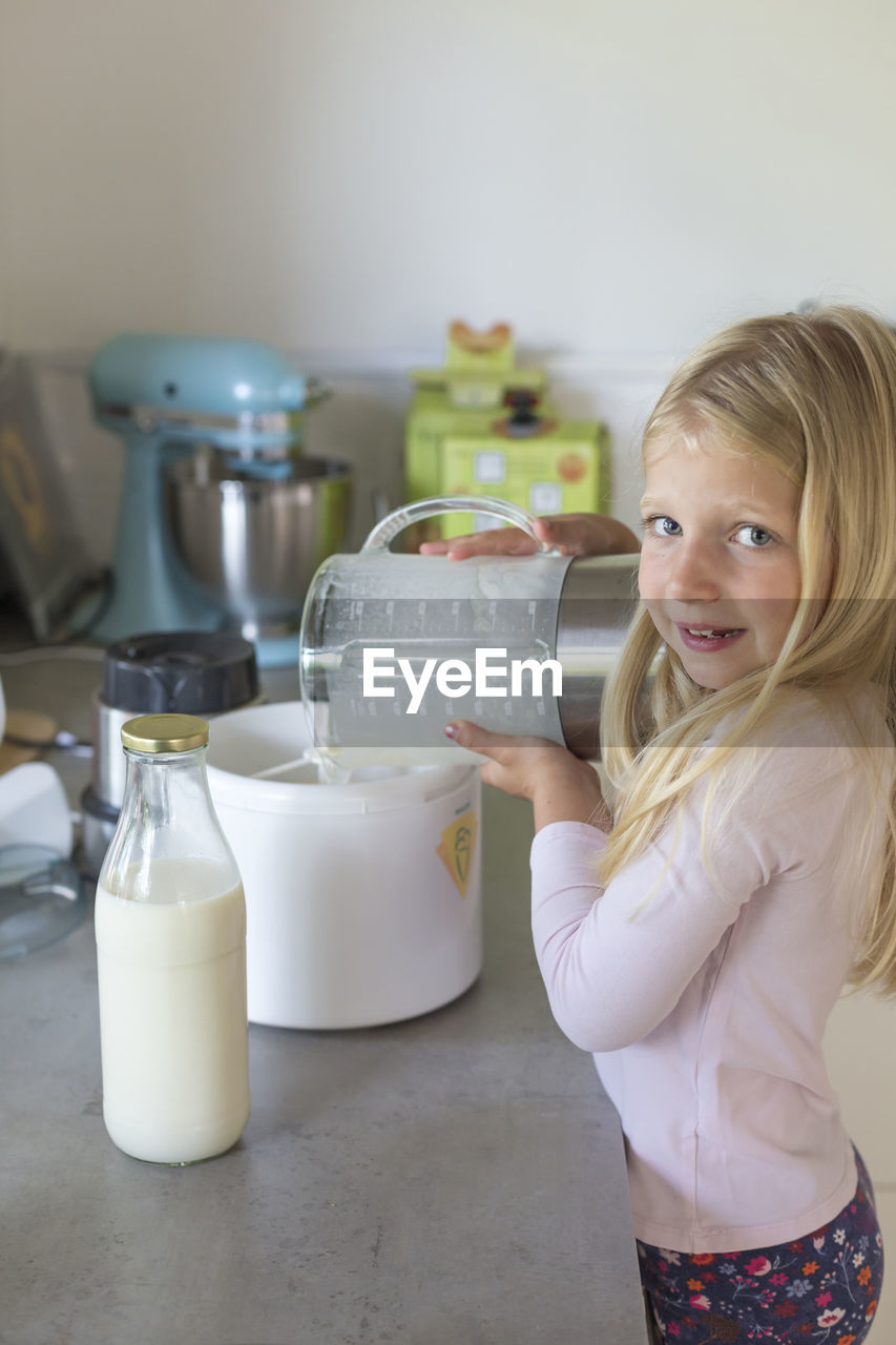 Smiling girl preparing food at home