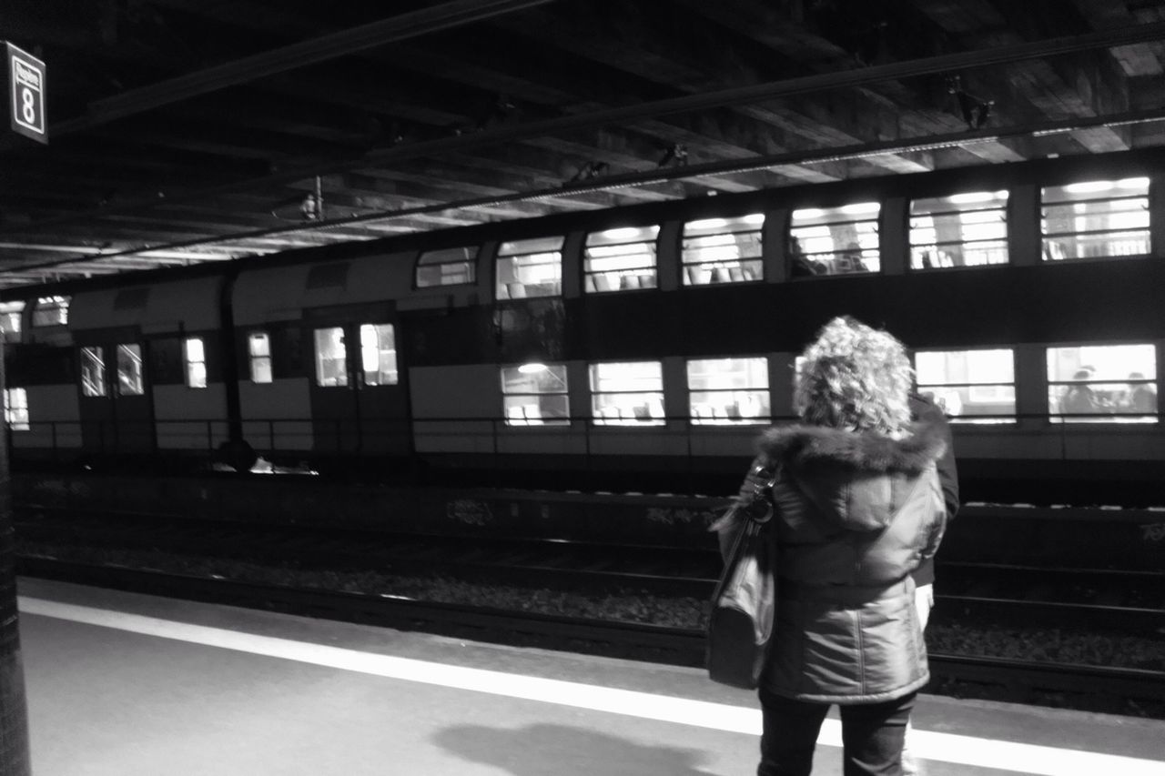 WOMAN STANDING ON RAILROAD TRACKS