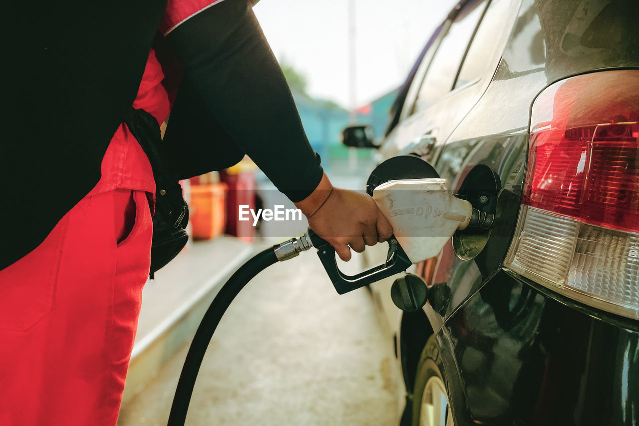 An officer at a gas station at work refueling a car