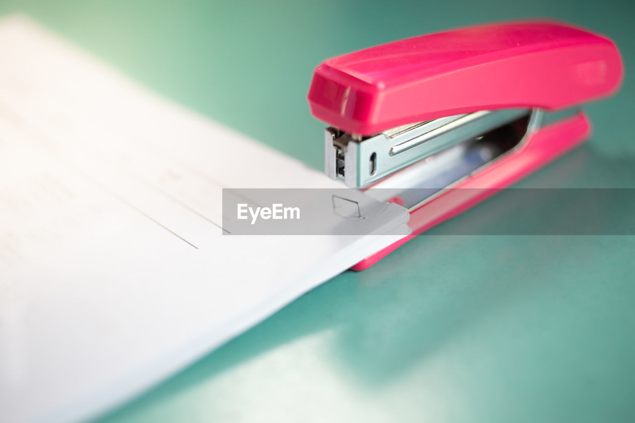 Close-up of stapler and papers on table