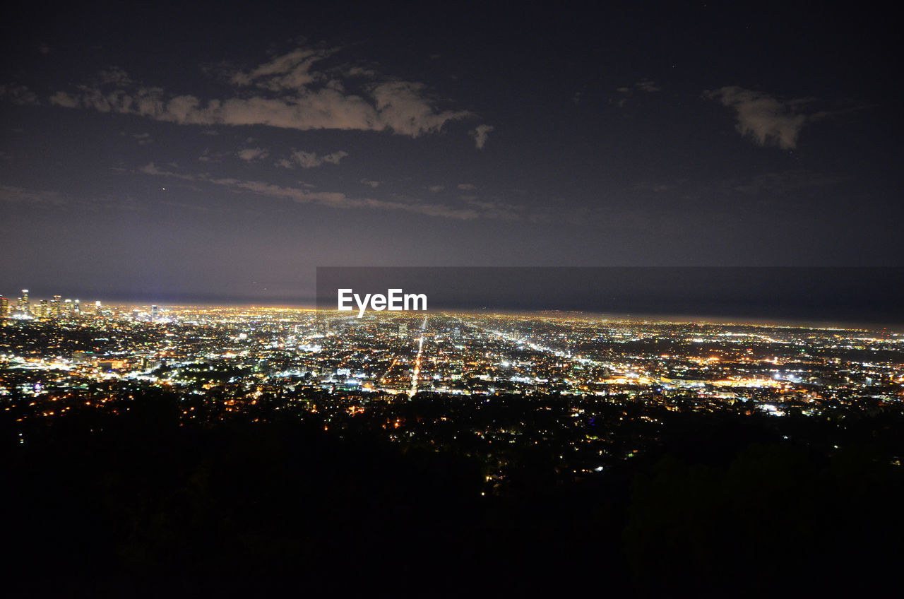 Aerial view of illuminated city against sky at night