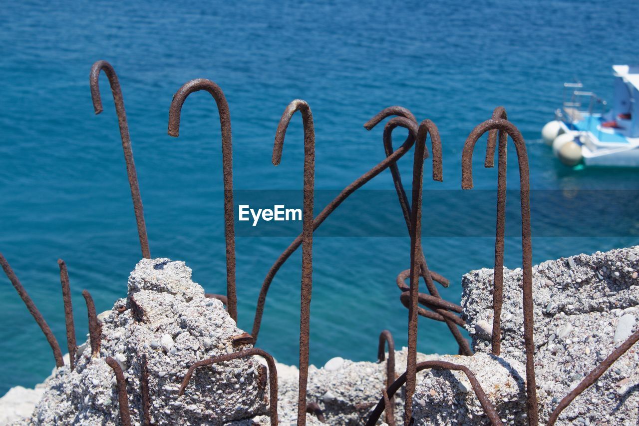 CLOSE-UP OF METAL CHAIN ON SEA SHORE