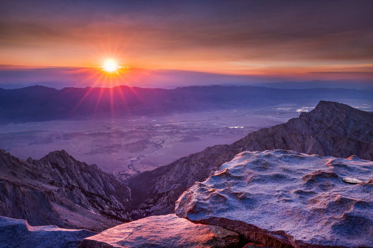 Scenic view of mountains against dramatic sky during sunset