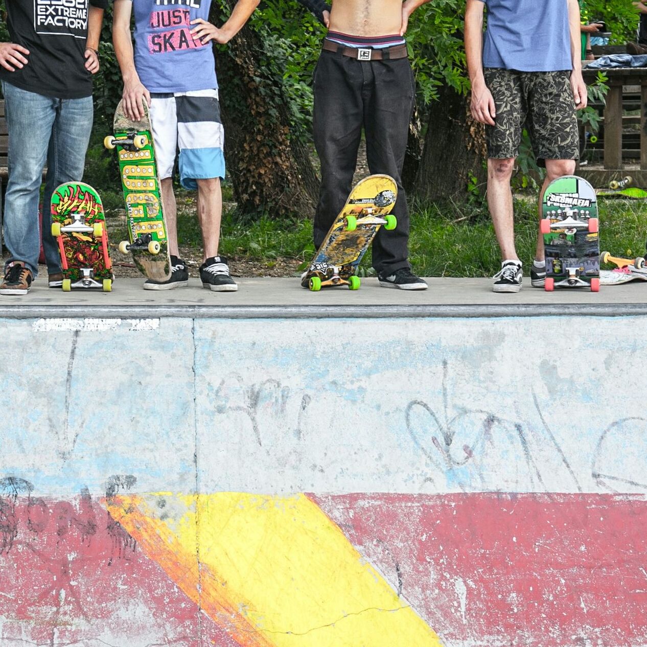 Low section of people with skateboard standing on street