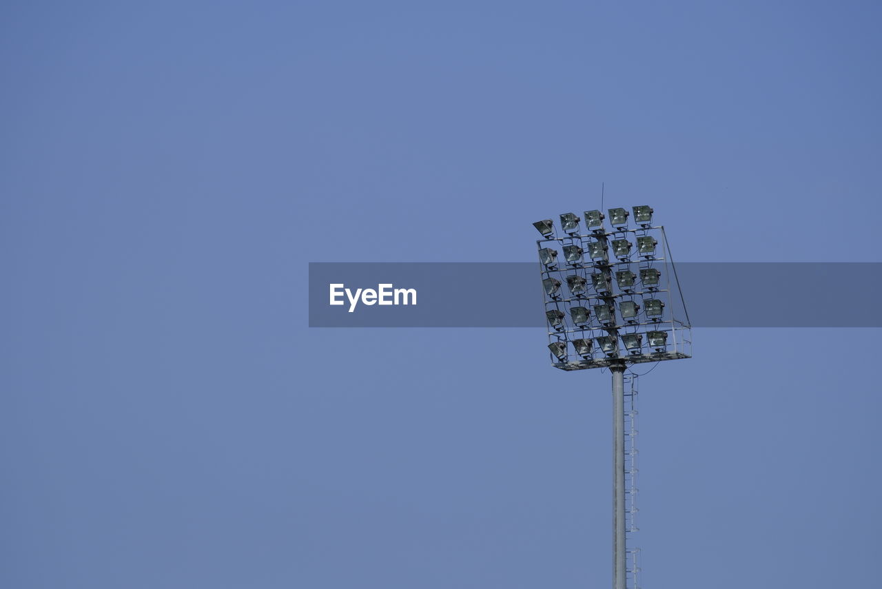 Low angle view of floodlight against clear blue sky