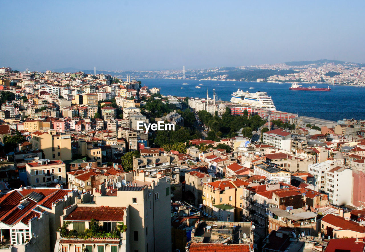 High angle view of townscape by sea against sky