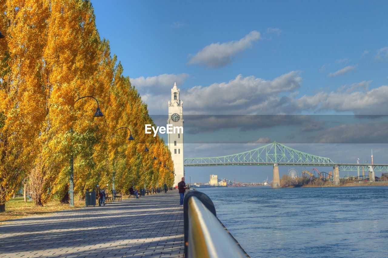 Autumn trees and clock tower by bridge over st lawrence river