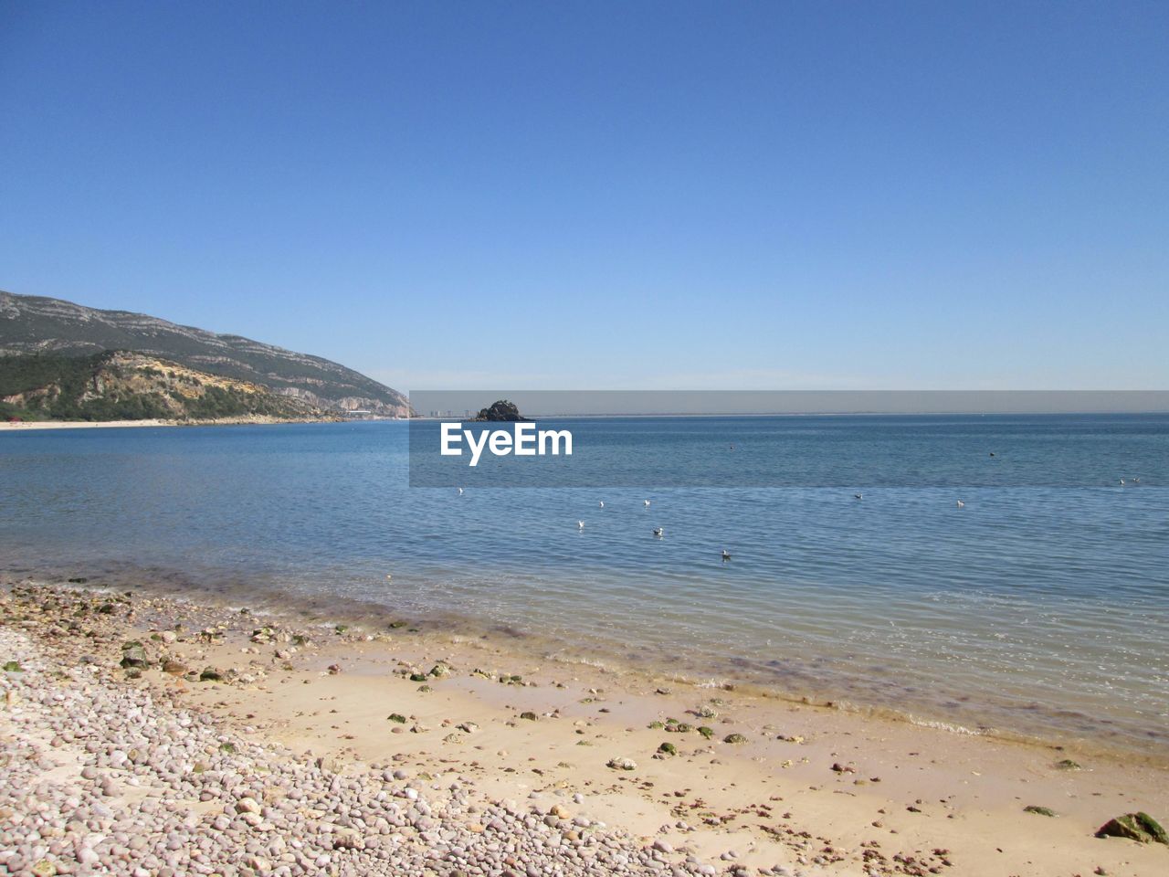 land, body of water, water, sea, sky, beach, scenics - nature, shore, beauty in nature, nature, clear sky, horizon, tranquility, sand, ocean, coast, tranquil scene, blue, travel destinations, environment, landscape, travel, sunny, no people, horizon over water, bay, coastline, tourism, day, mountain, vacation, wave, outdoors, holiday, idyllic, copy space, trip, non-urban scene, water's edge, seascape, summer, sunlight