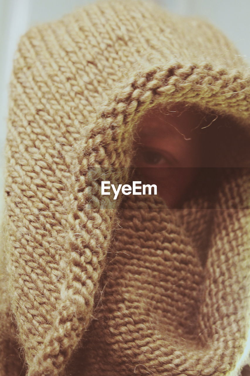 Close-up of man covering face with sweater
