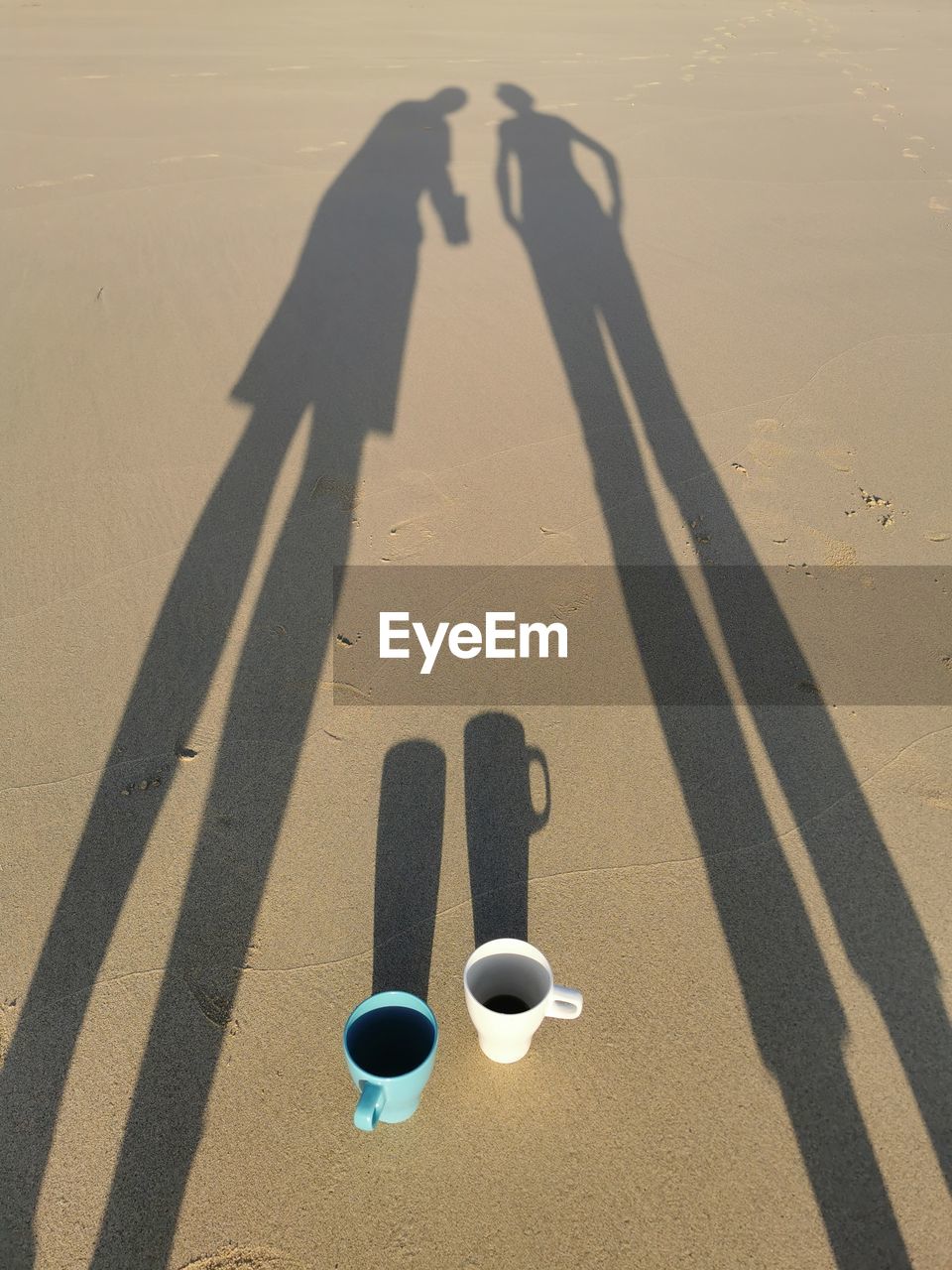 shadow, sunlight, sand, nature, land, high angle view, two people, blue, beach, day, leisure activity, lifestyles, men, outdoors, adult, togetherness, cup, focus on shadow, art, women