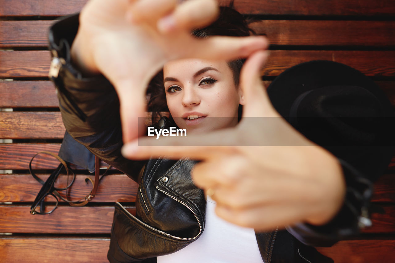 close-up of young woman sitting on wooden table