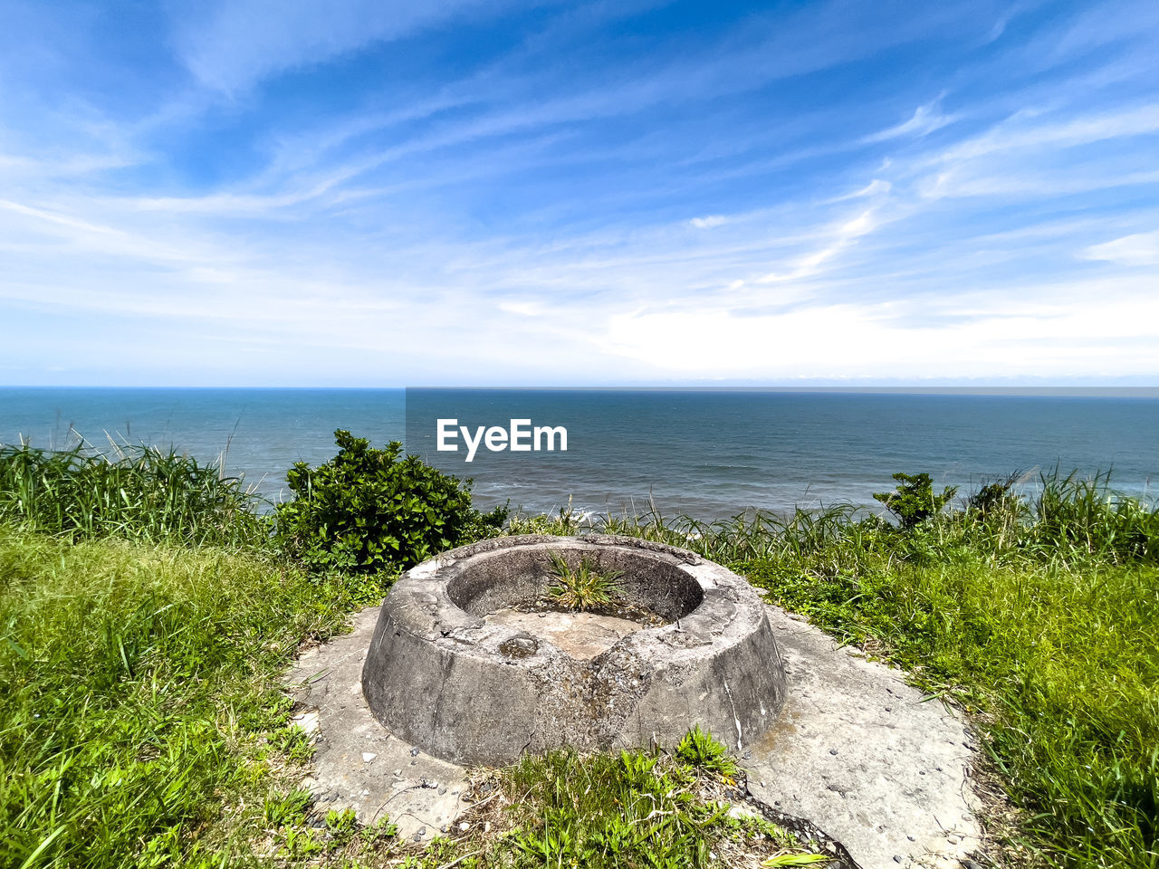 sea, sky, water, horizon over water, coast, nature, land, rock, horizon, plant, scenics - nature, beach, shore, beauty in nature, cloud, grass, tranquility, ocean, no people, tranquil scene, terrain, day, blue, cliff, landscape, outdoors, environment, travel destinations, travel, coastline, tourism, history, sunlight, body of water, tree, non-urban scene, architecture, idyllic, vacation, green, urban skyline, seascape, the past, bay