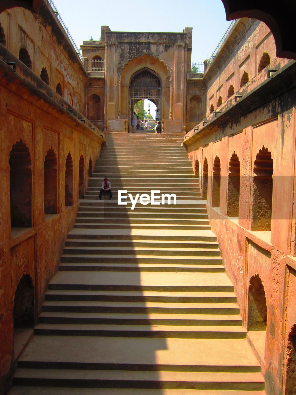 Steps leading towards arch gate on sunny day