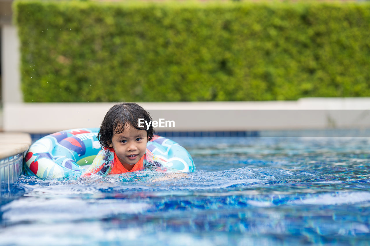 Little adorable girl have fun at outdoor swimming pool