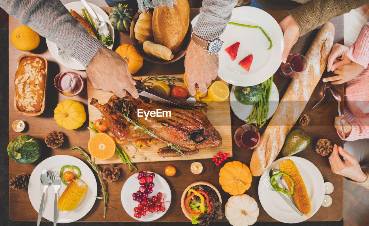 Cropped image of people eating food on table