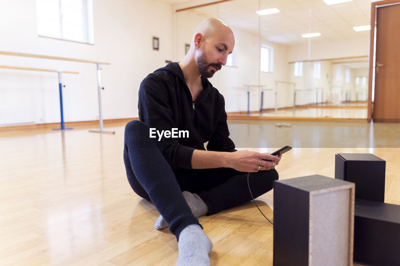 Ballet dancer using cell phone in ballet studio