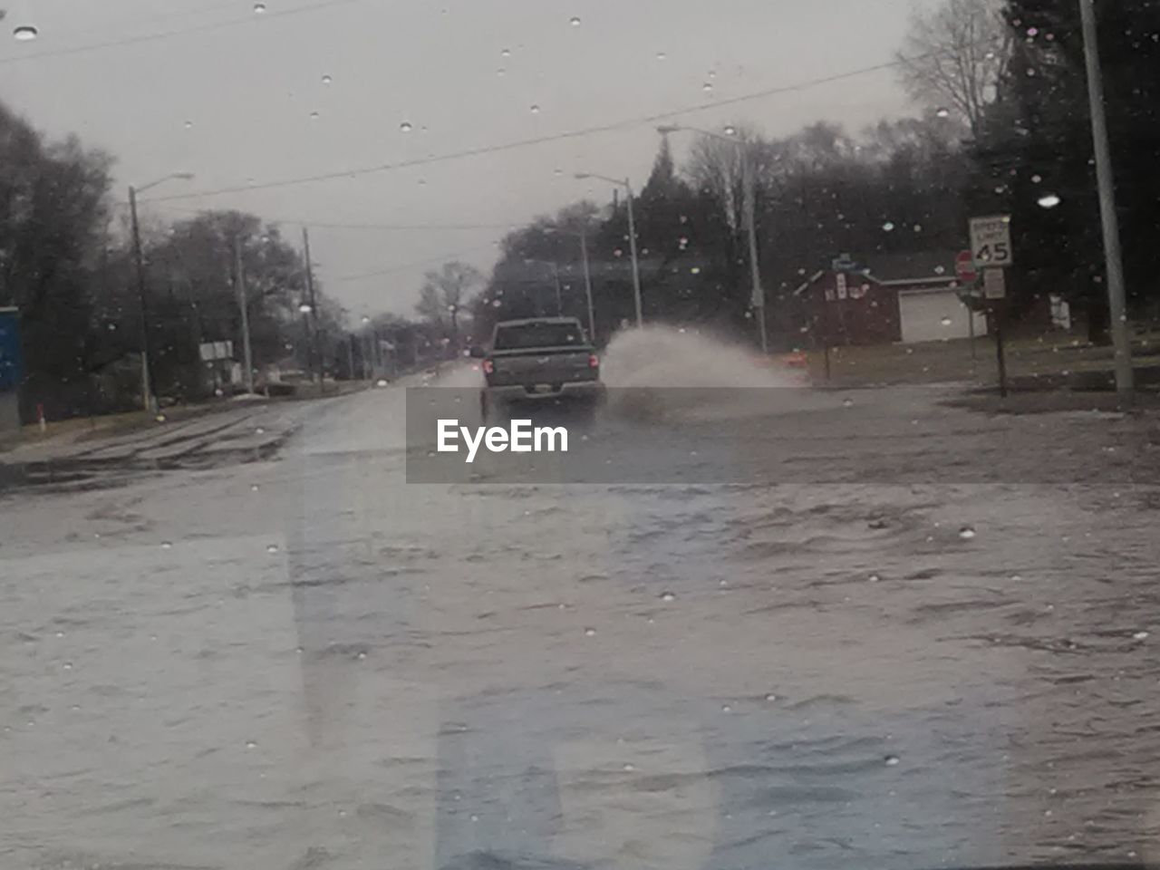 WET CAR ON STREET IN RAINY SEASON