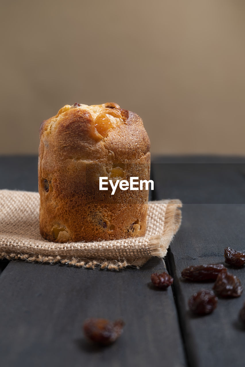 Italian dessert mini panettone with raisins on dark wooden background