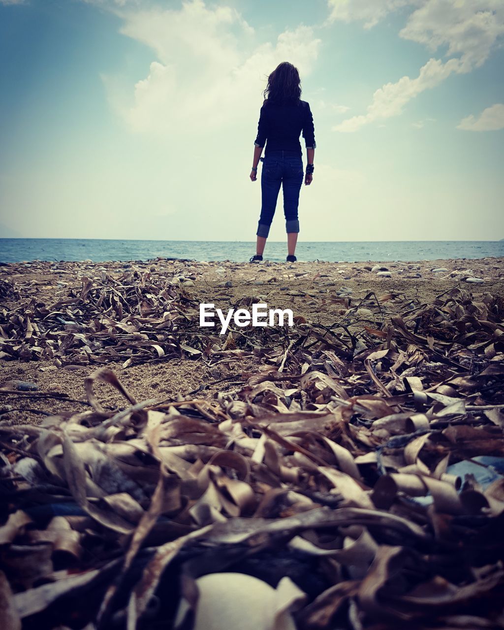 FULL LENGTH REAR VIEW OF WOMAN STANDING AT BEACH