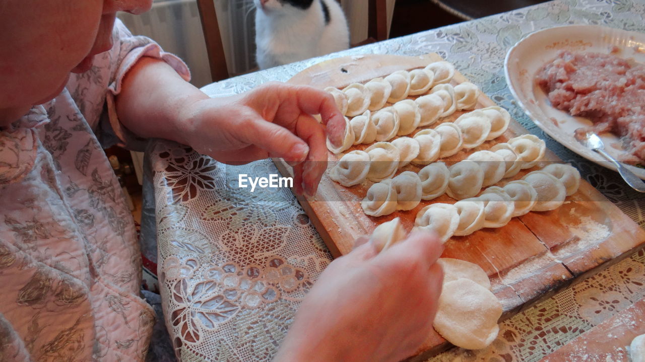 Cropped image of woman preparing dumplings at home