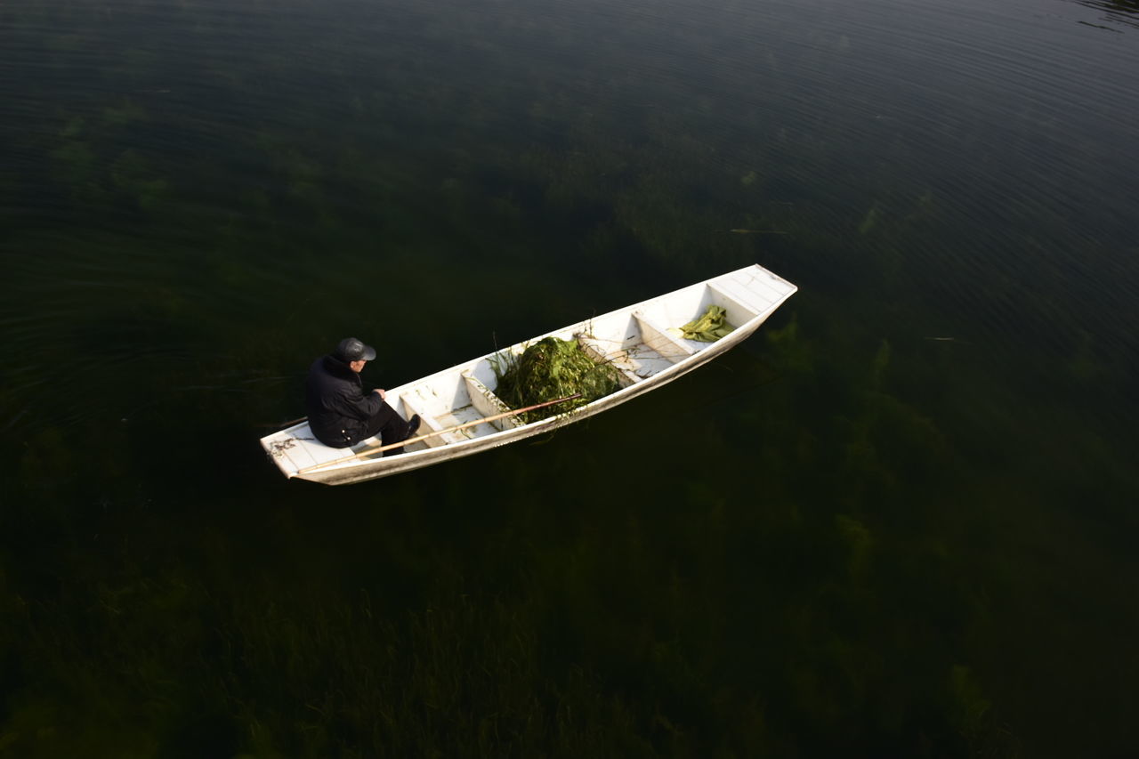 VIEW OF MAN ON BOAT IN LAKE